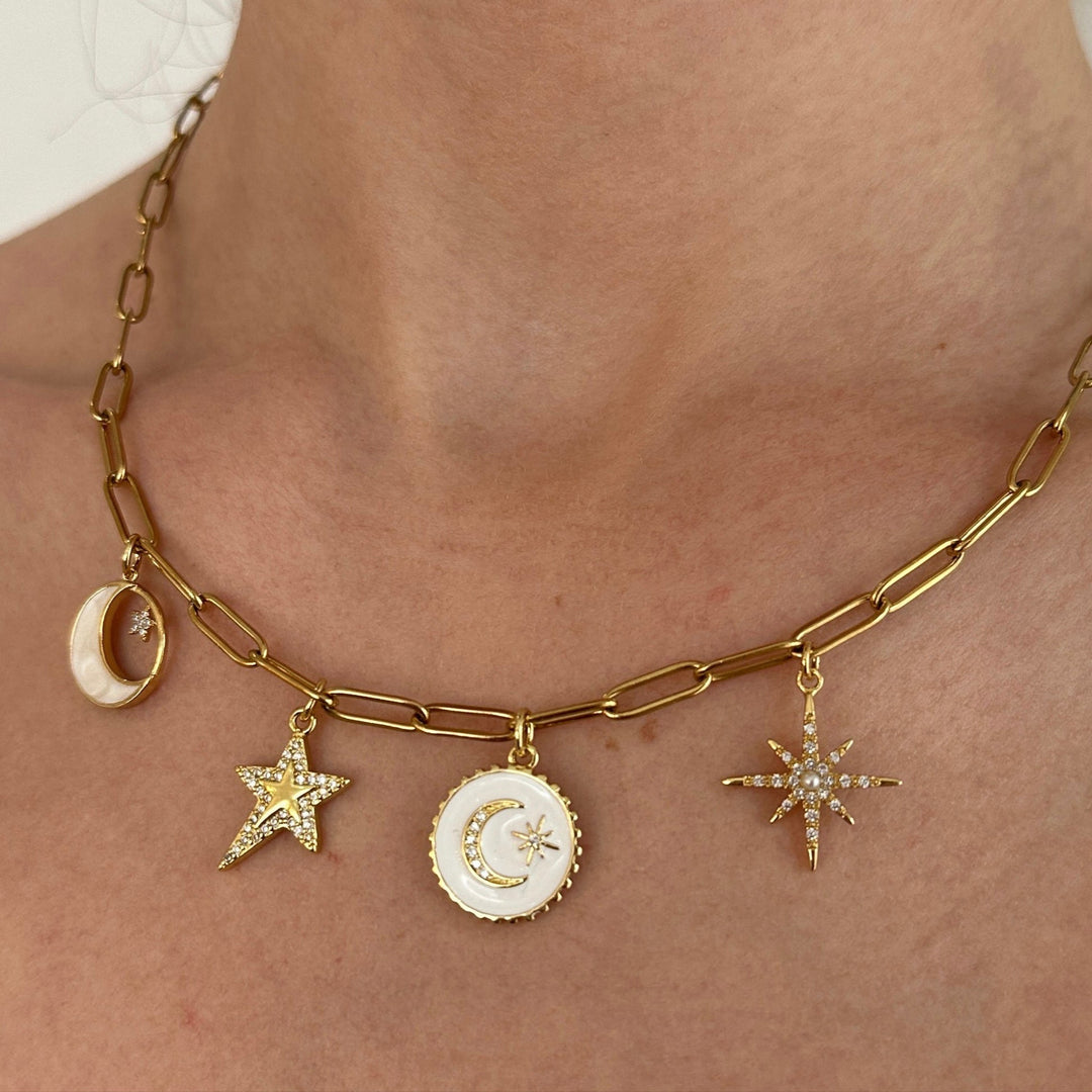 Gold necklace with star and moon charms on a person's neck