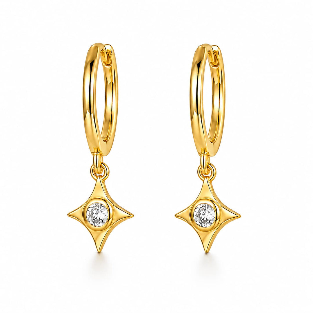 A pair of gold huggie hoop earrings with dangling four-pointed star charms, each set with a small clear round gemstone, shown on a clean white background.