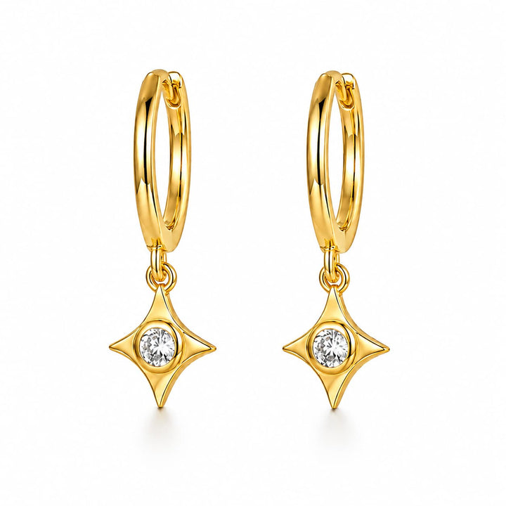 A pair of gold huggie hoop earrings with dangling four-pointed star charms, each set with a small clear round gemstone, shown on a clean white background.
