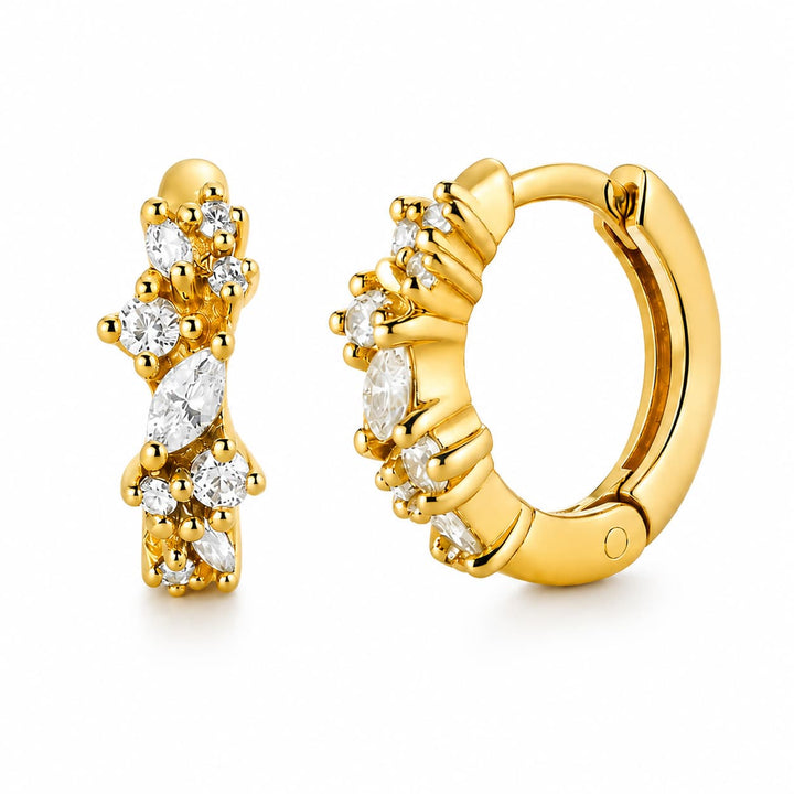 A pair of gold huggie hoop earrings with marquise and round-cut clear gemstones, shown on a clean white background.