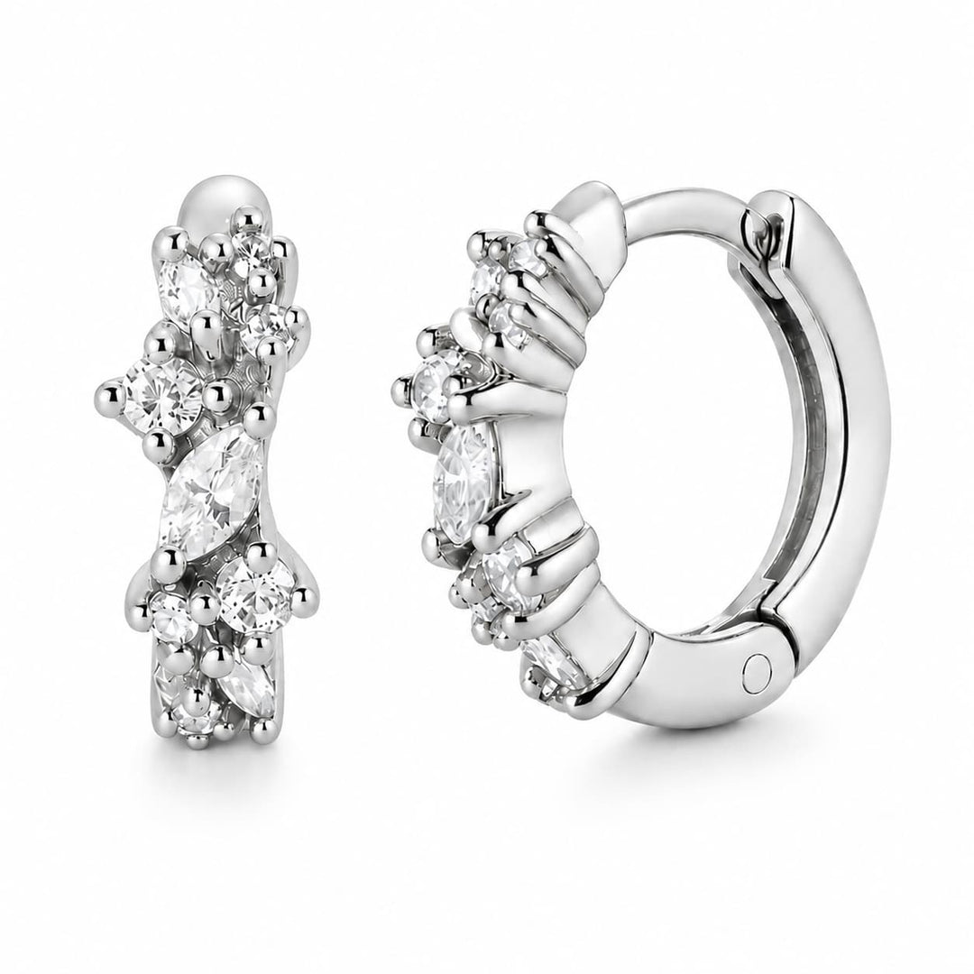 A pair of silver huggie hoop earrings decorated with marquise and round-cut clear gemstones, shown from both front and side angles on a white background.