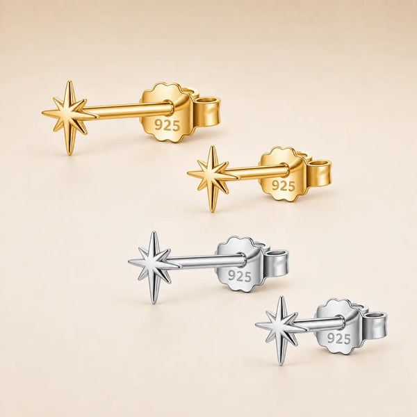 Four 925 sterling silver star-shaped barbell stud earrings, showing both gold-toned and silver-toned finishes on a warm beige background.